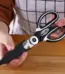 A chef holding kitchen scissors.